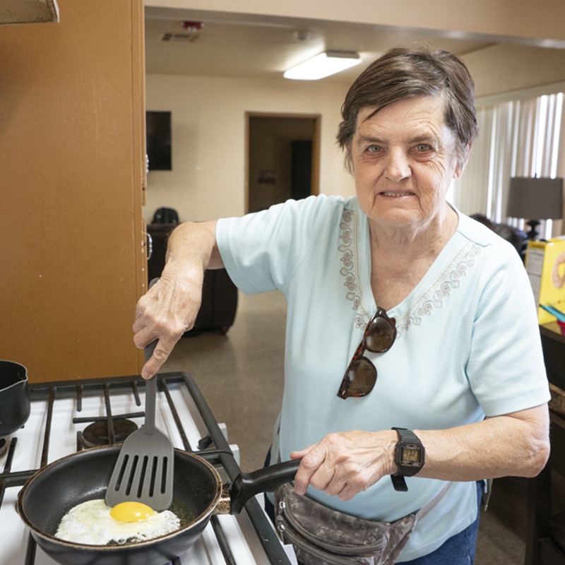 Independent Living Woman frying an egg