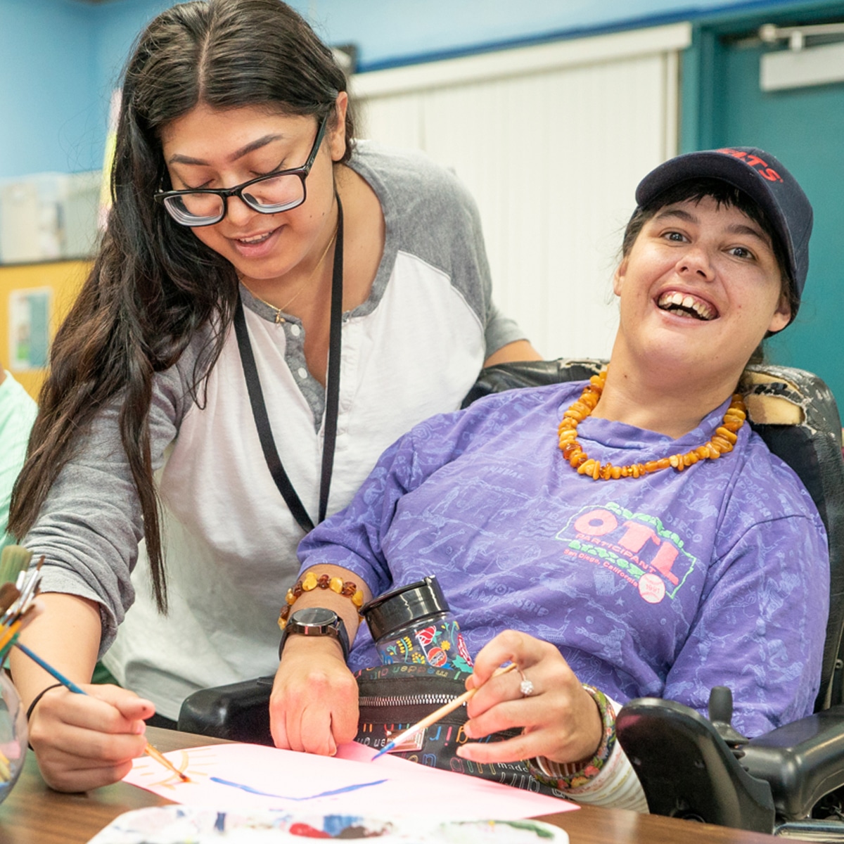 Respite Services Woman assisting a disabled woman with an art project